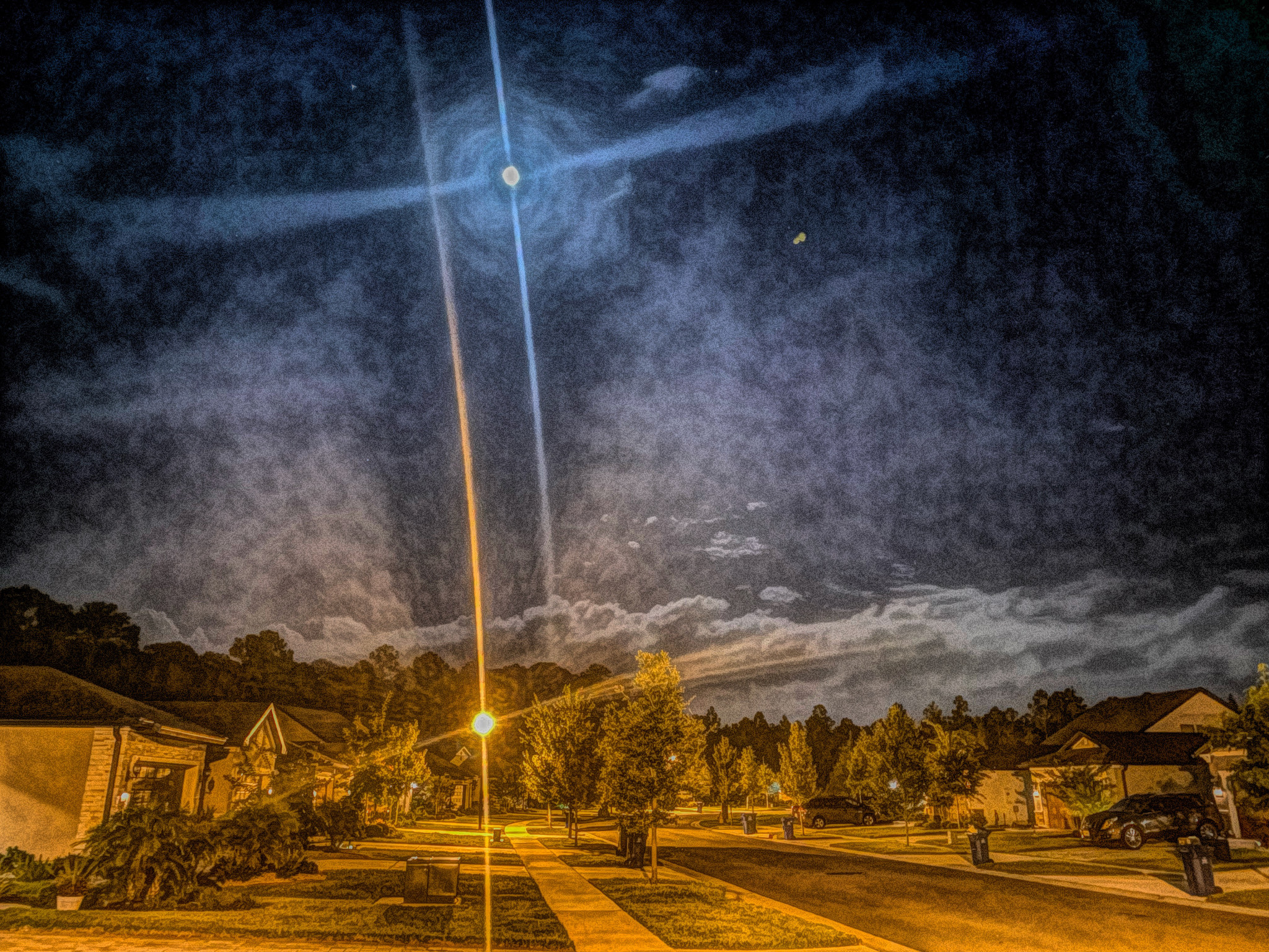 Stylized photo of a night sky on a suburban street.