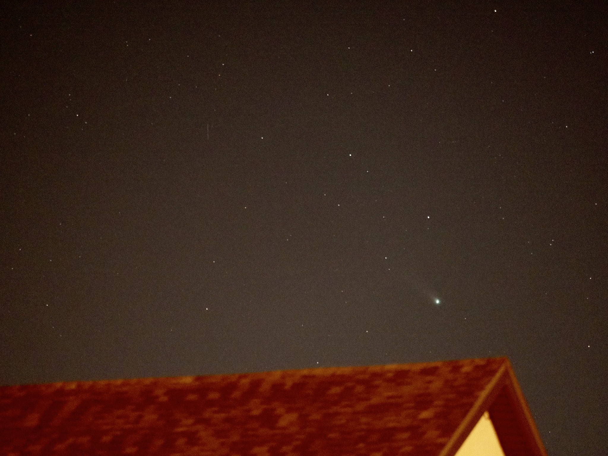 Comet Leonard over the roof of the house across the street.