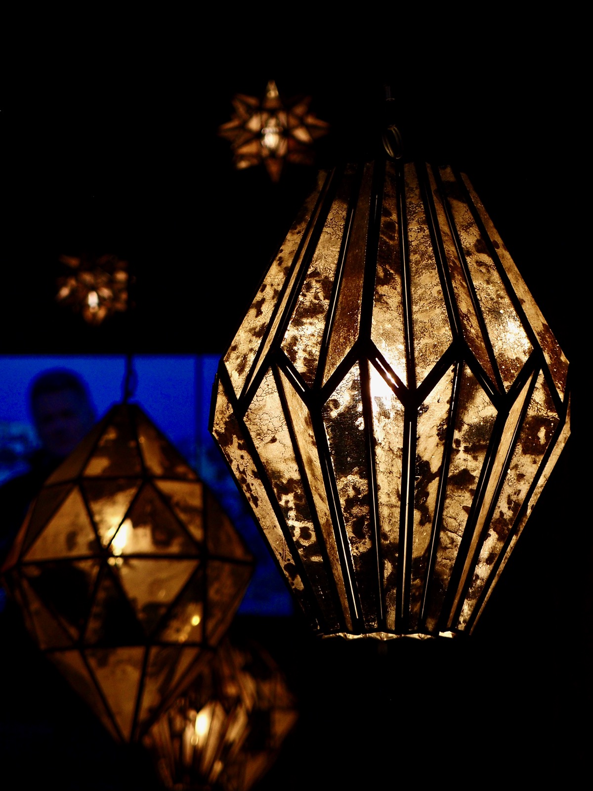 Some hanging lamps in a restaurant against a dark background