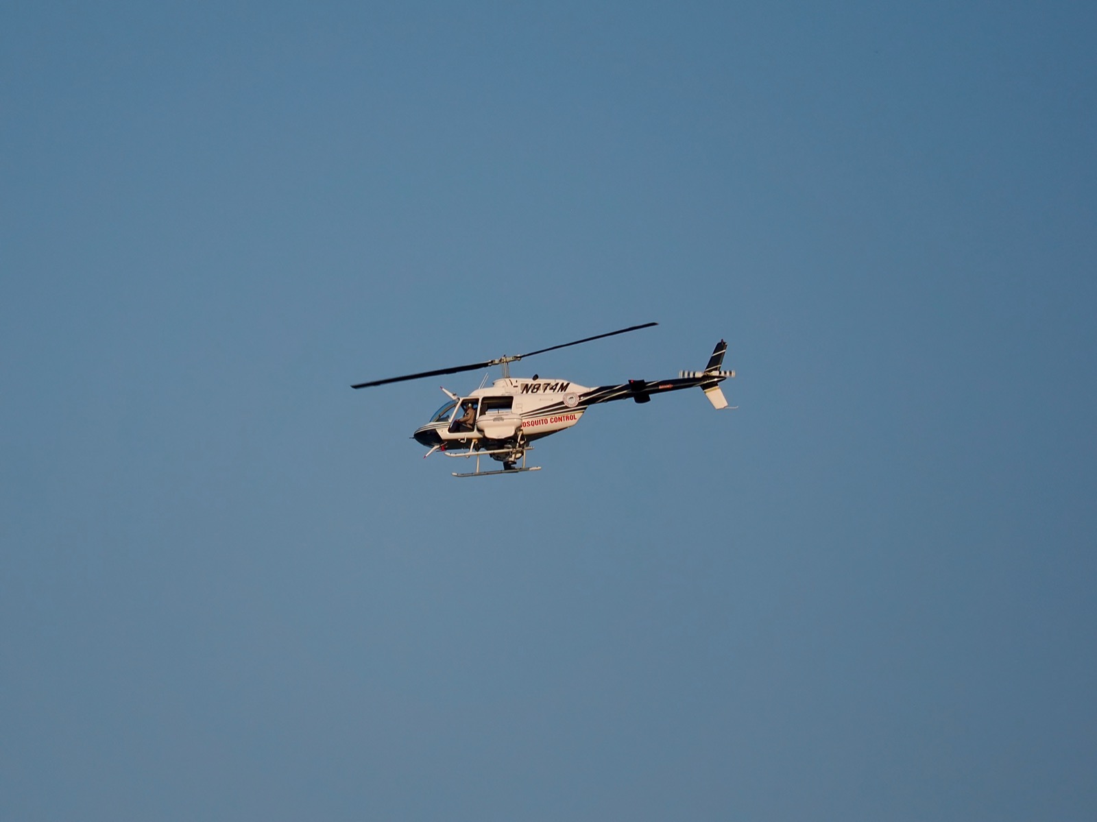 Telephoto image of an airborne mosquito control helicopter
