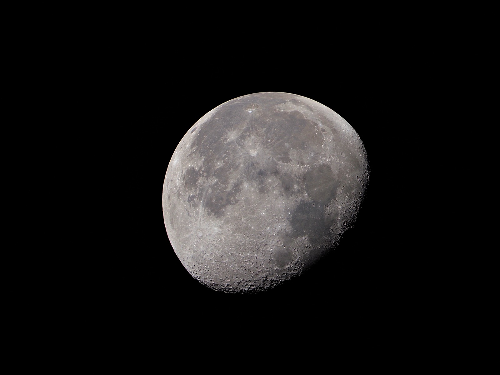 Telephoto closeup of waning gibbous moon against a black sky