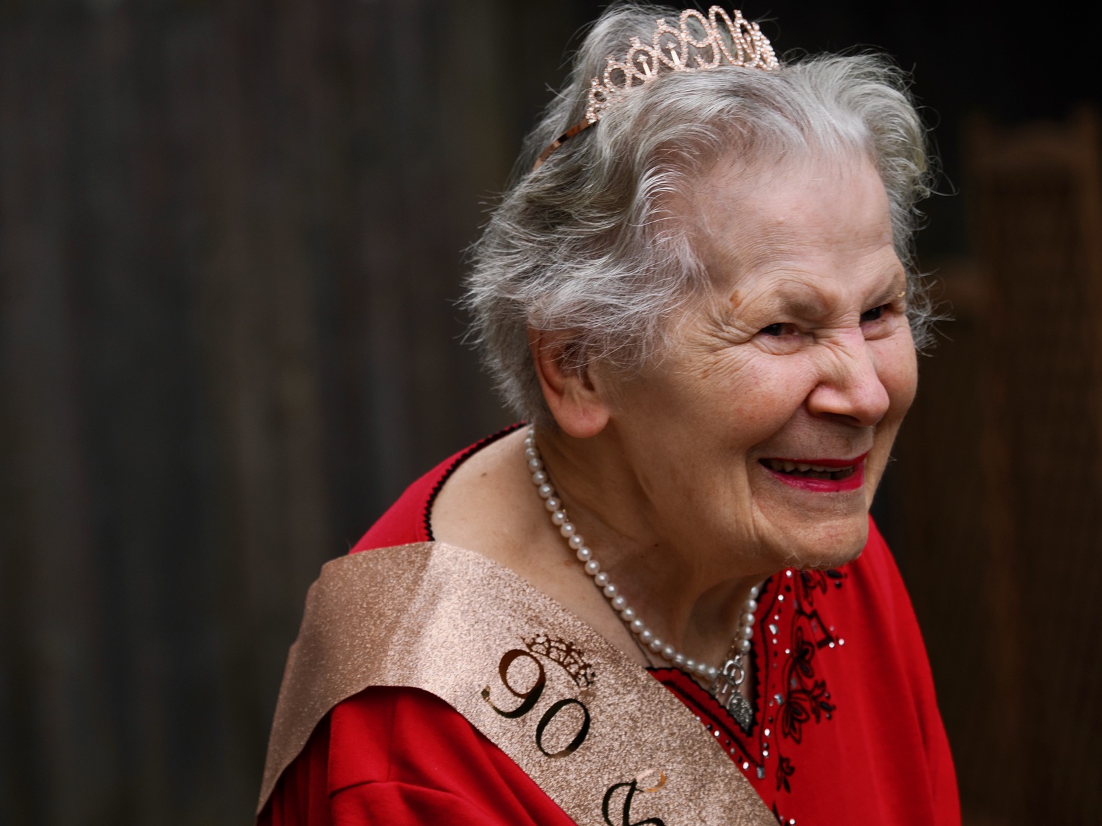 Photo of Frances Rogers wearing a tiara noting the number 90 and a gold banner for her 90th birthday