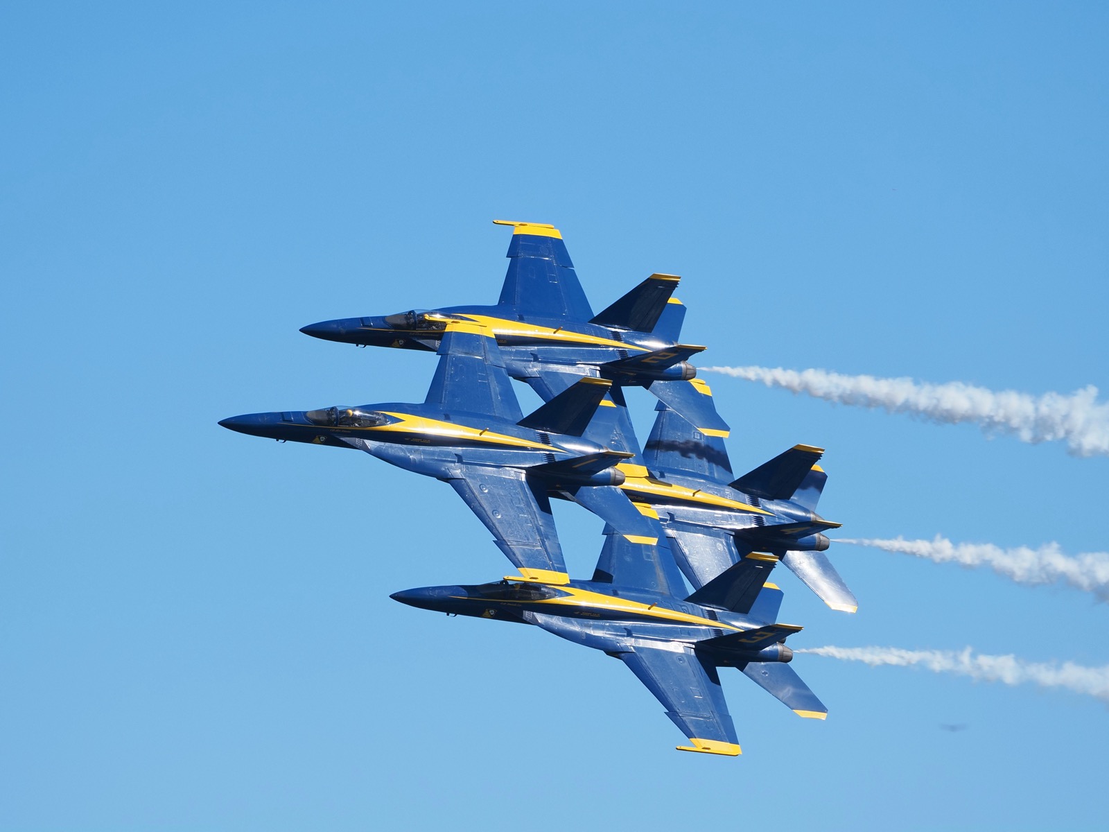 Four Blue Angel F-18 aircraft in a tight diamond formation