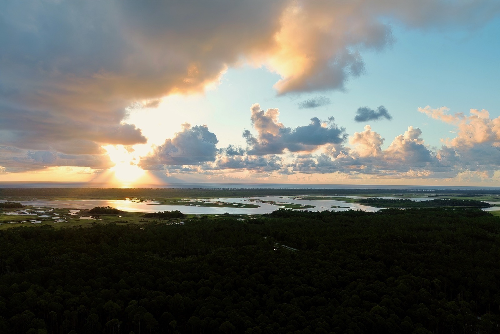 Sun rising over the Atlantic Ocean and the Tolomato River with clouds from a drone