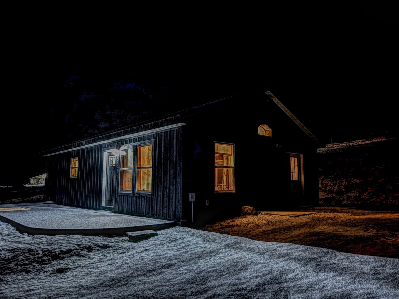 Photo of a small house at night illuminated from within, with a Painteresque app filter applied