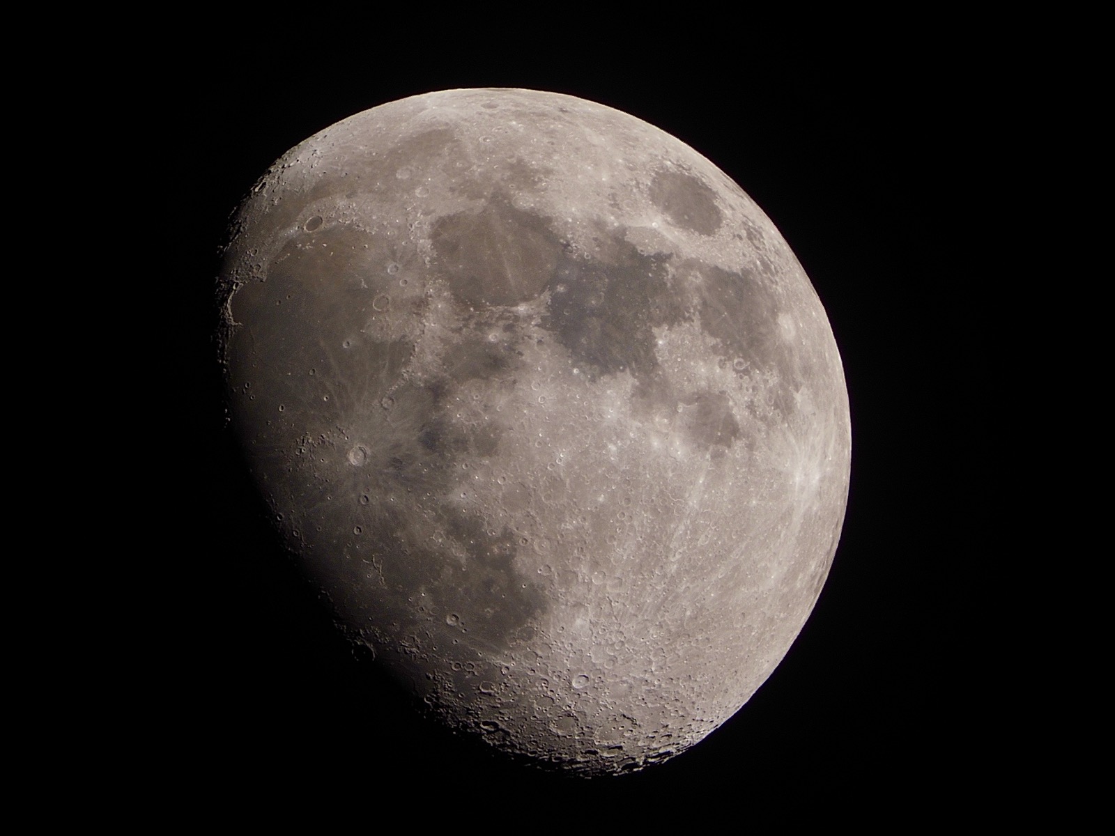 Telephoto closeup of waxing gibbous moon approx 75% illuminated
