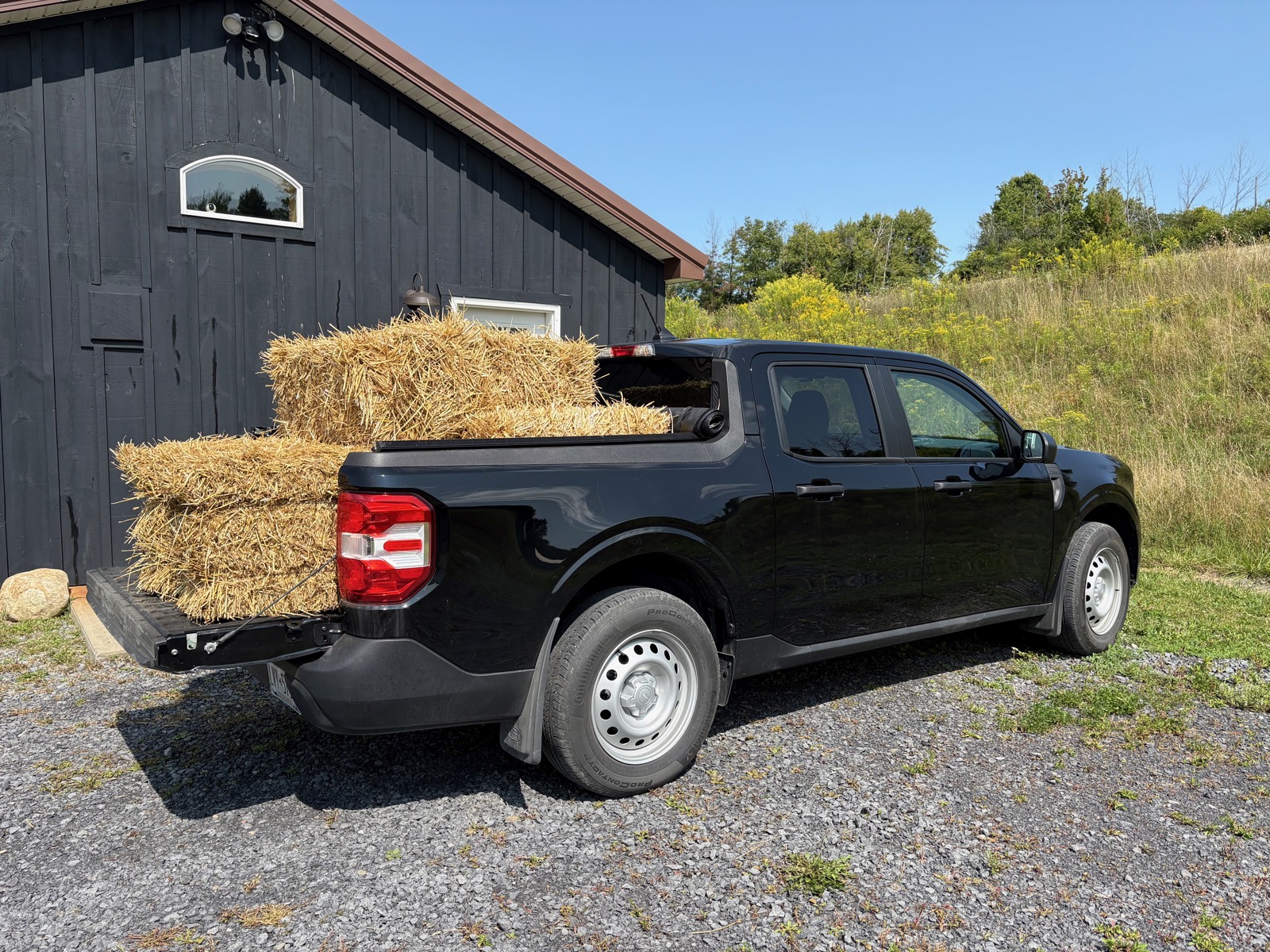 Photo of a Ford Maverick with eight bales of straw in the tiny bed.