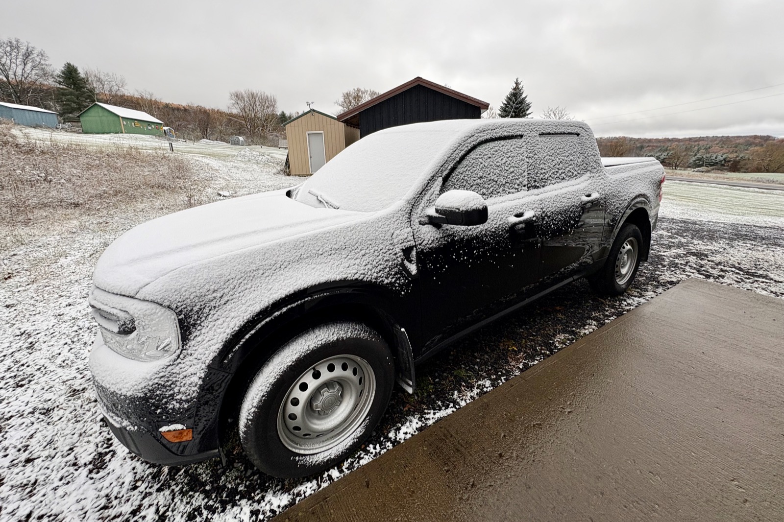 Black Ford Maverick frosted in snow