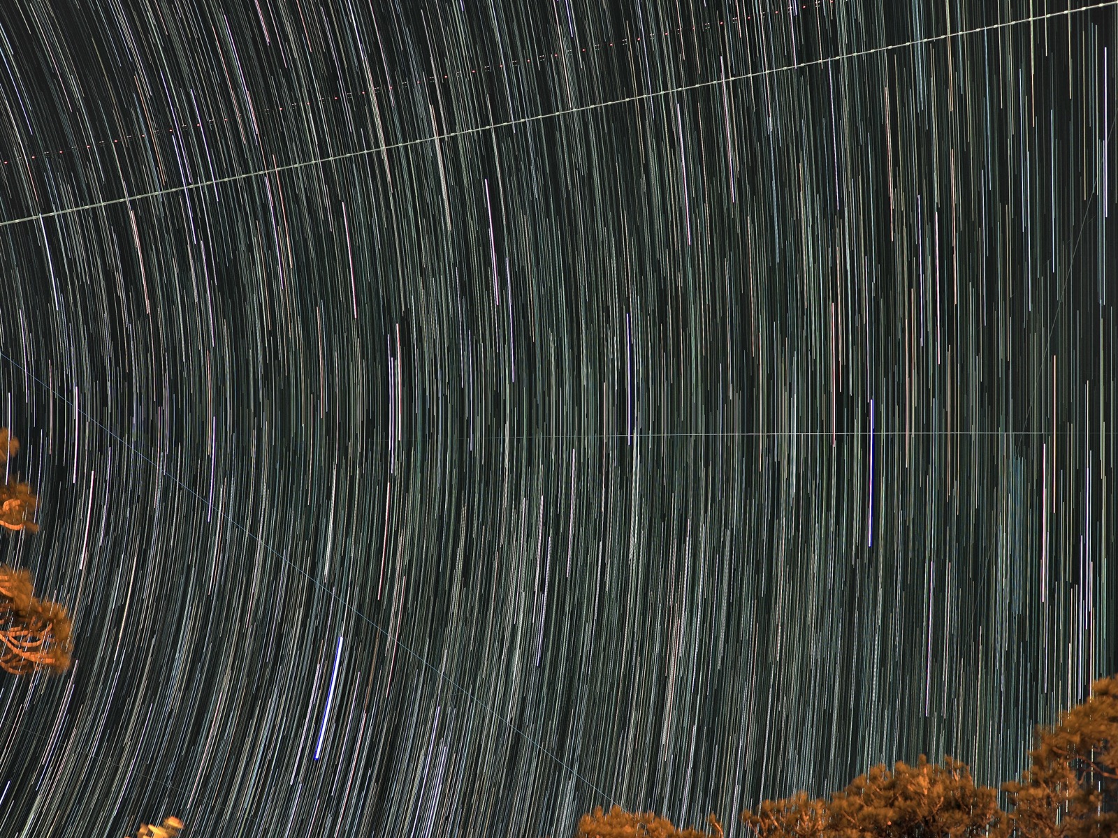 Live Composite image of star trails overhead.