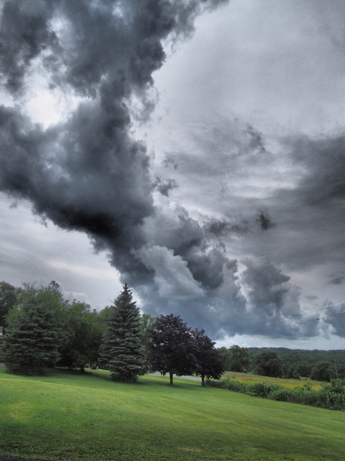 Dramatic Tone color image of a cloud formation about some trees in a rural setting