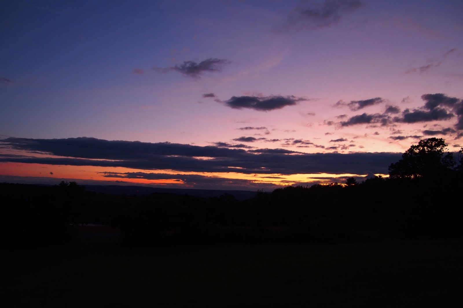 Evening twilight sky with foreground in shadow, some long thin clouds 
