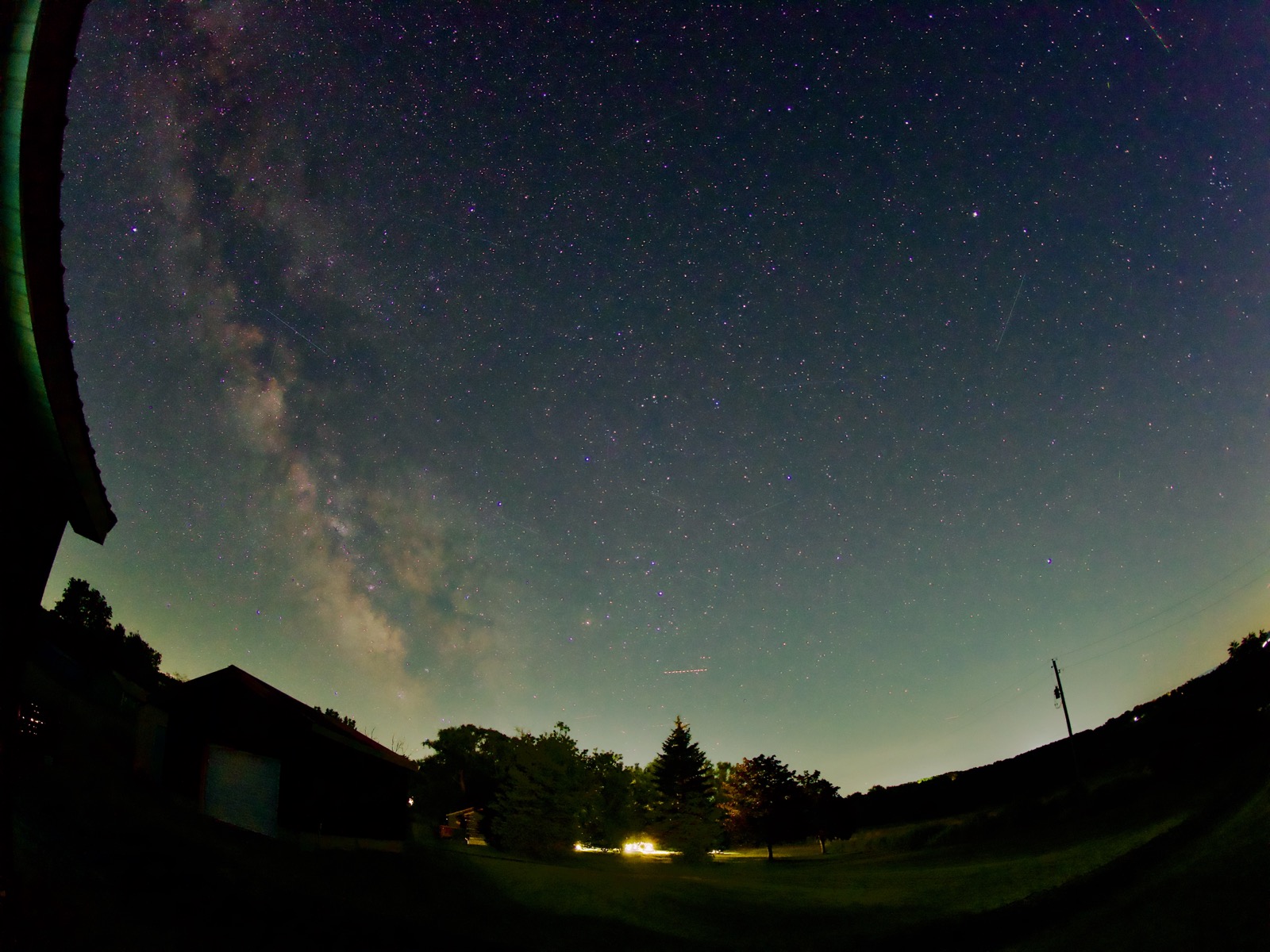 Fisheye shot of the Milky Way above a house in a rural landscape