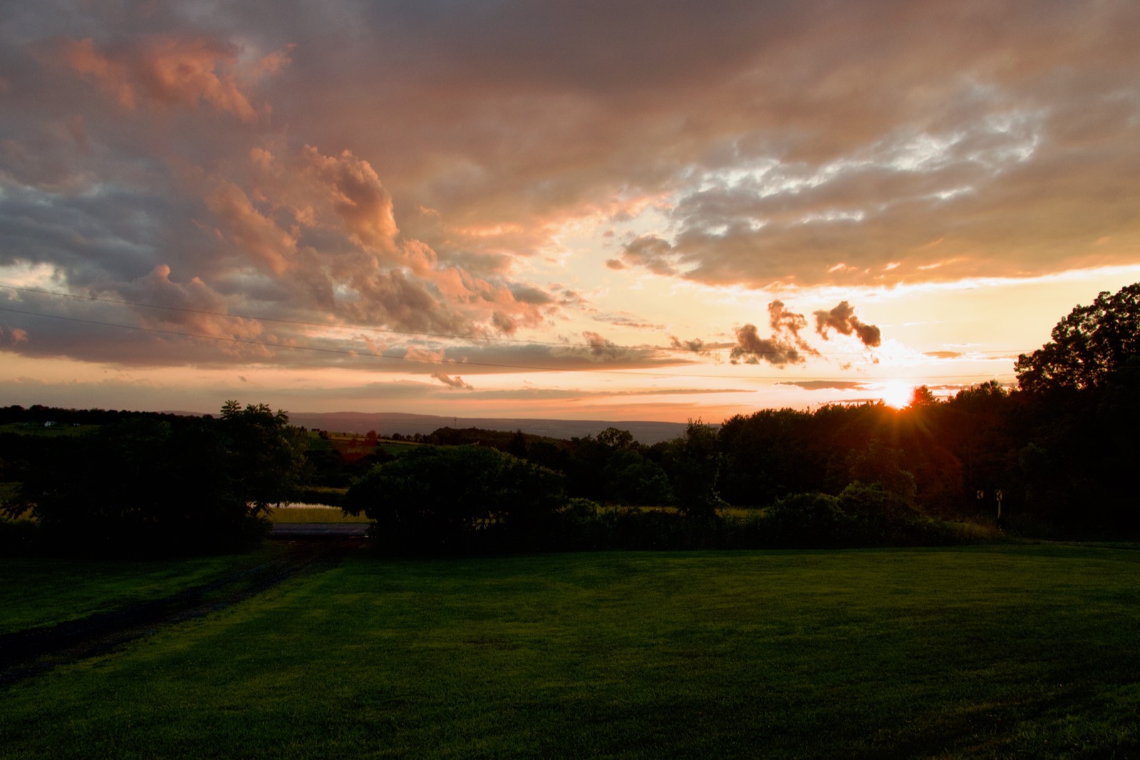 Clouds illuminated by the setting son in a rural landscape.