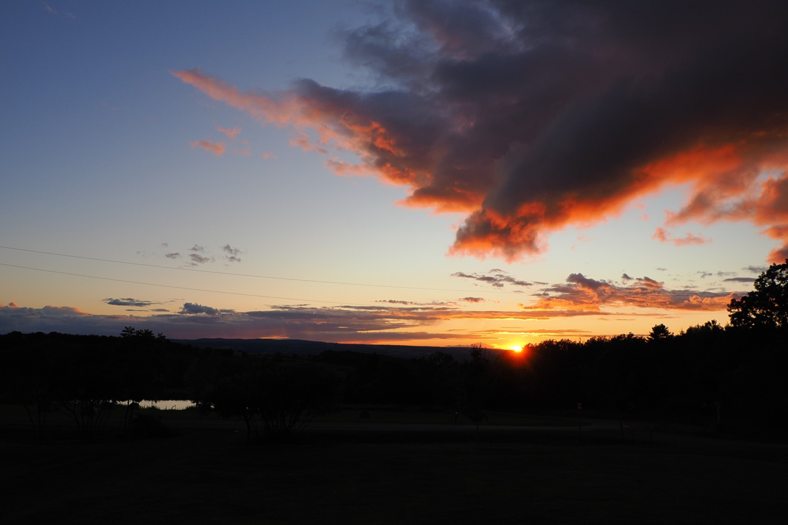 Just some reddish clouds and a dark horizon with the sun setting 