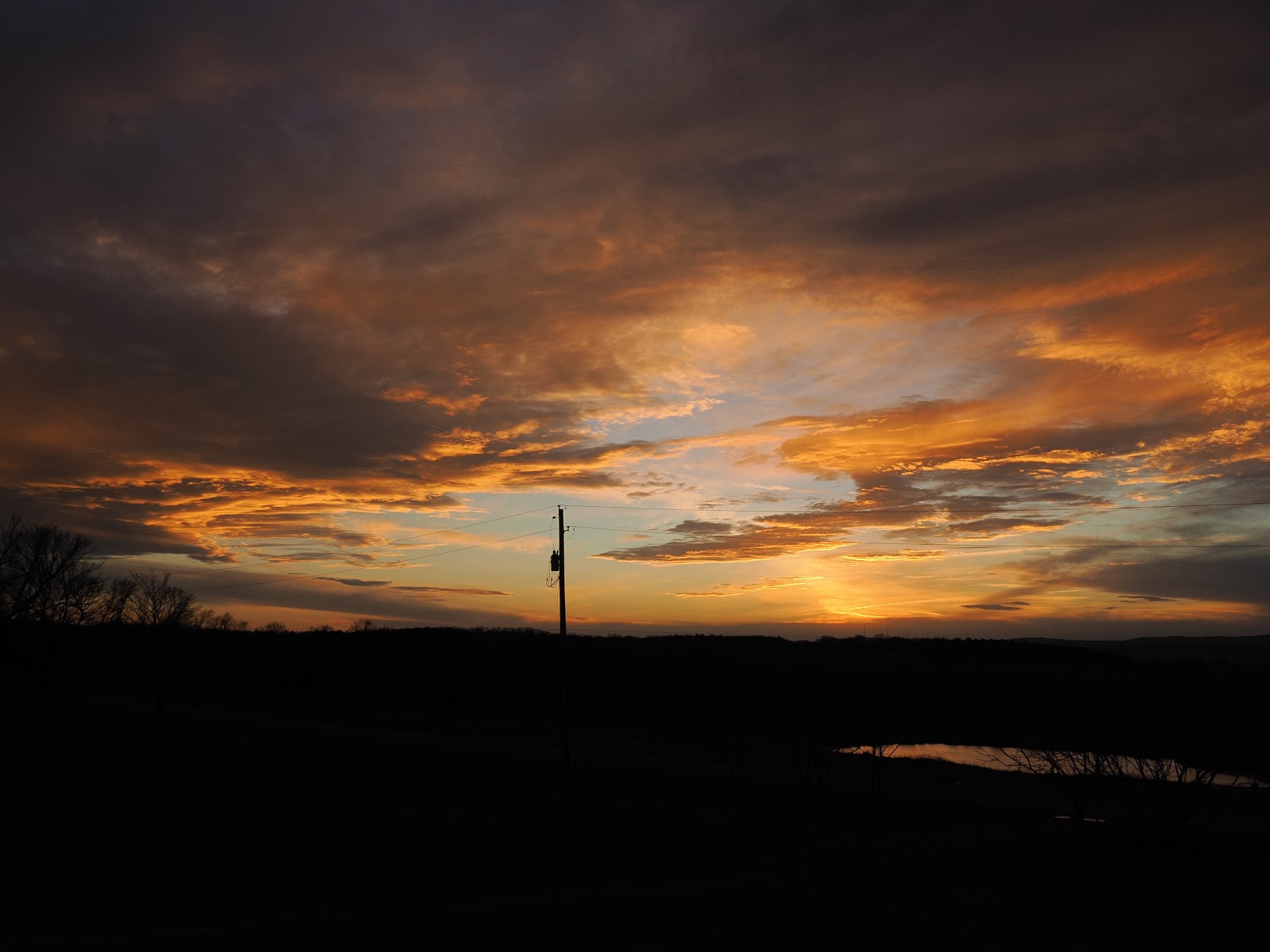 Broken clouds illuminated from below by the setting sun.