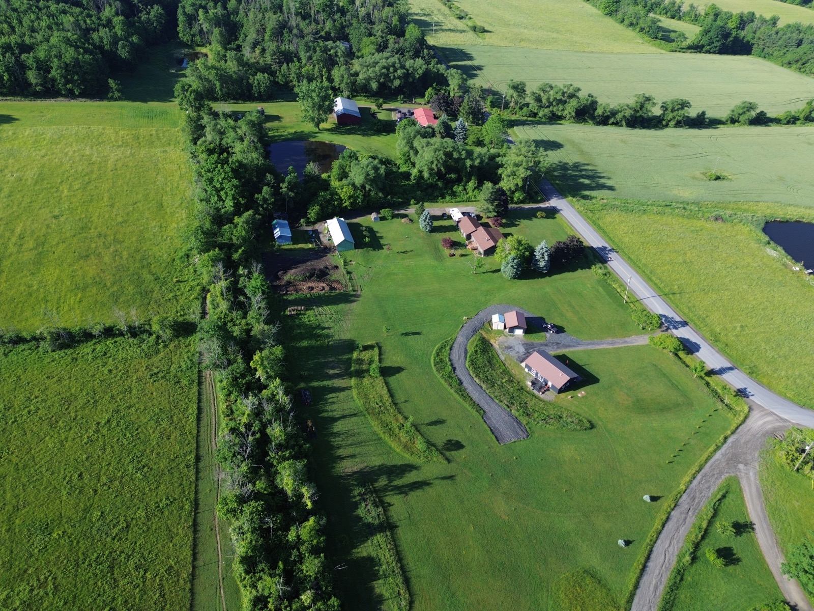 Overhead image shot from a drone of a house and garage in a rural landscape