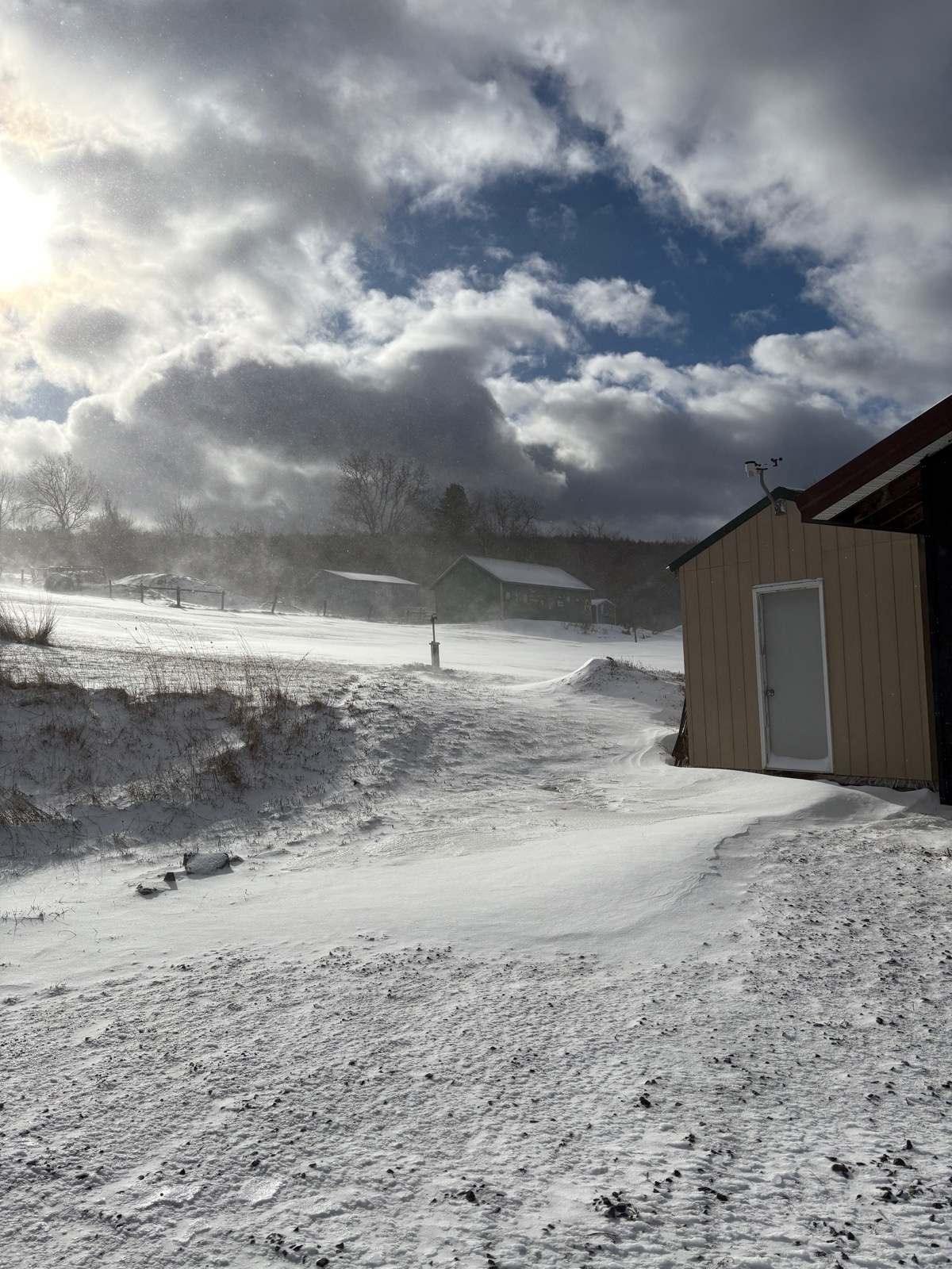 Clouds and blowing snow in a rural landscape