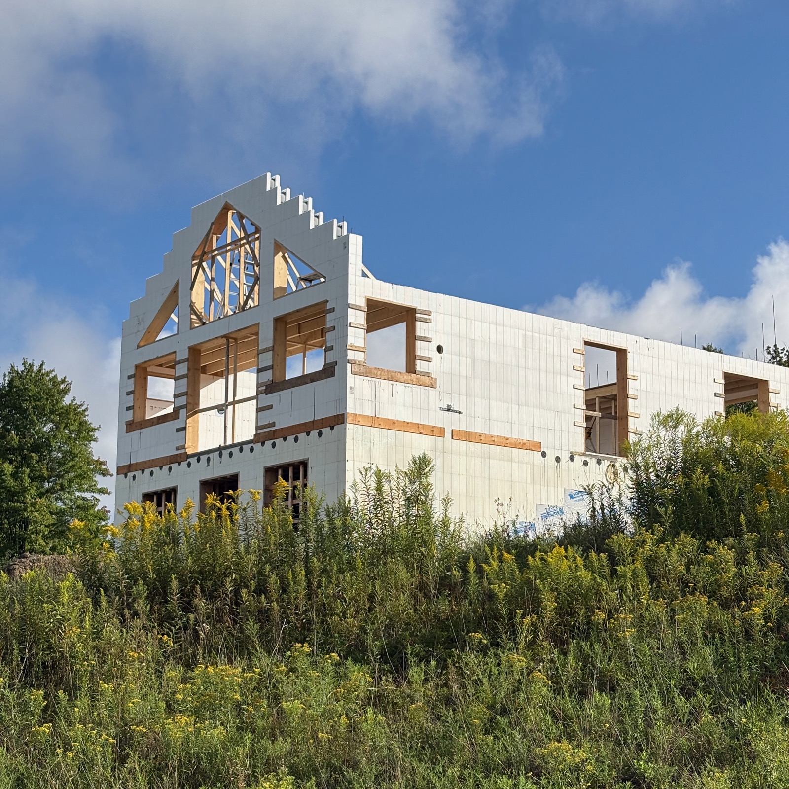 ICF home under construction with the gable end mostly stacked and awaiting cutting. 