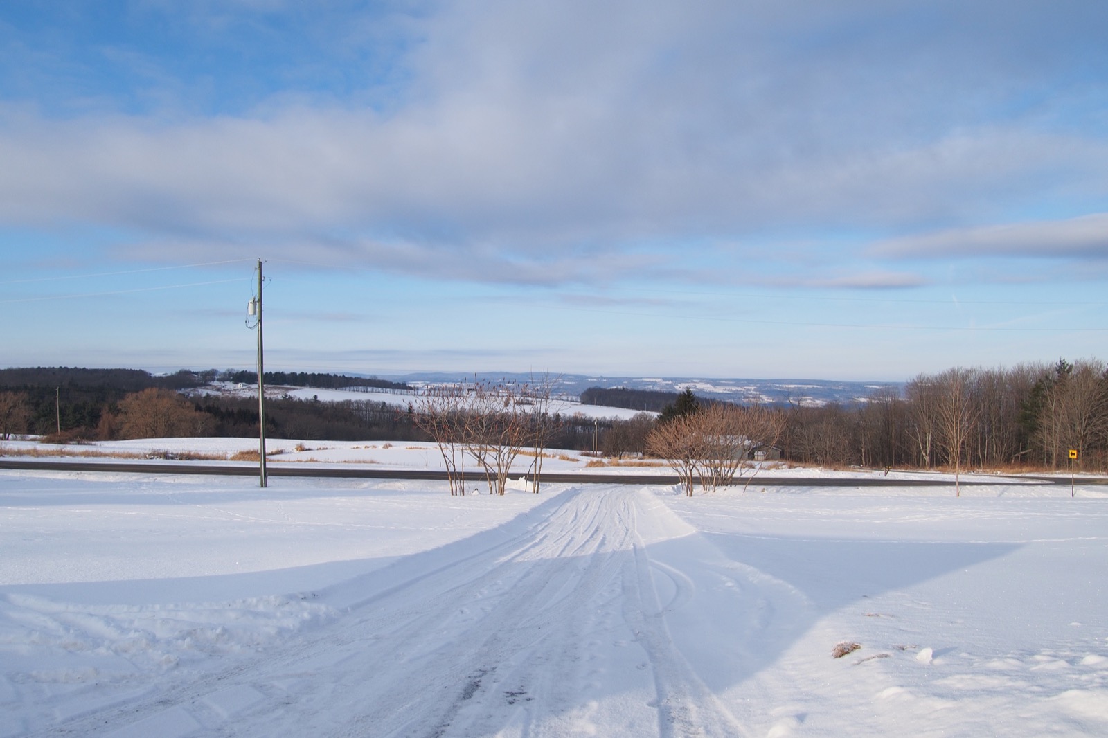 Wide angle snowy rural landscape, blue sky, likght clouds