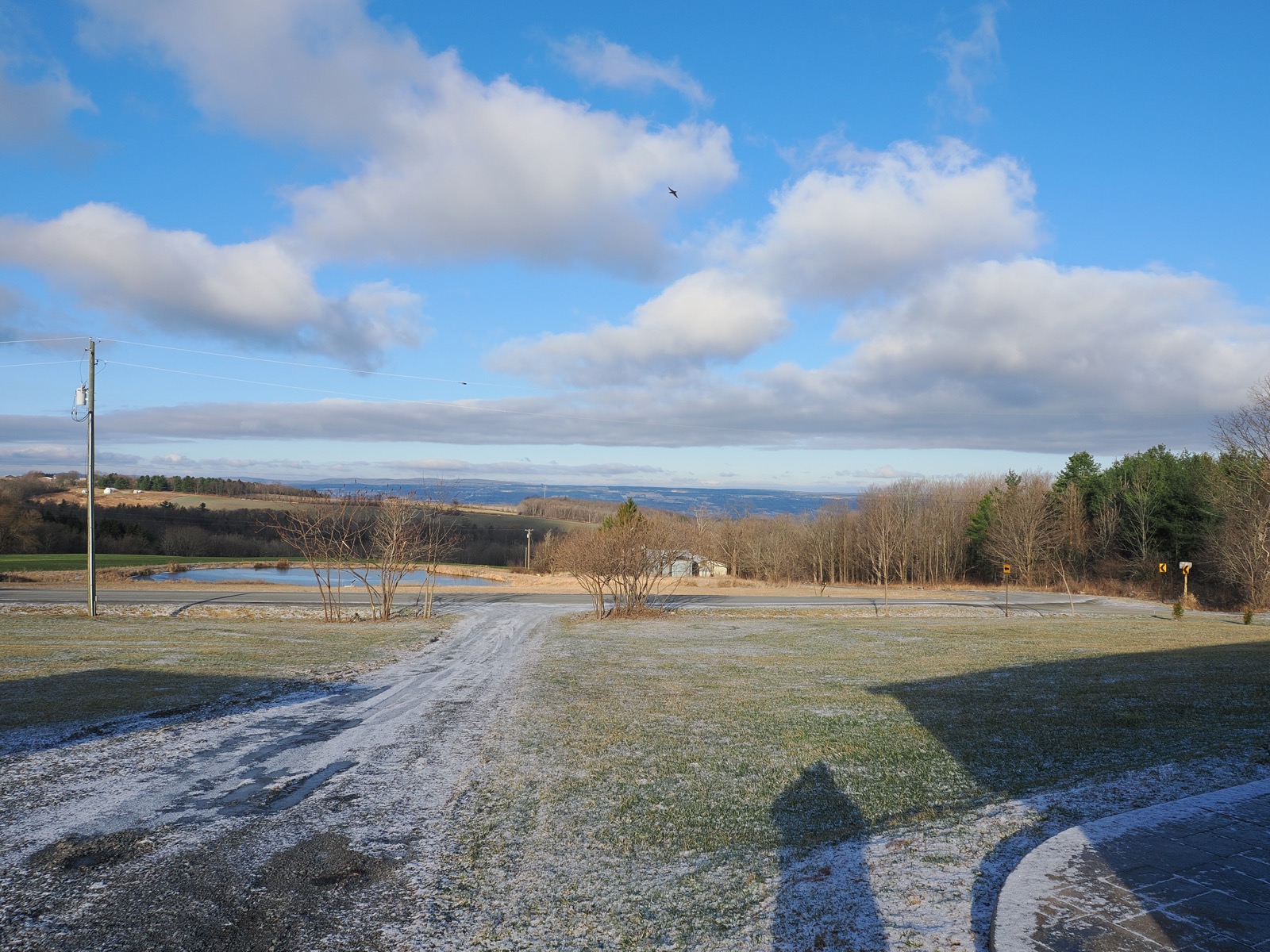 Light clouds against a blue sky above a rural landscape 