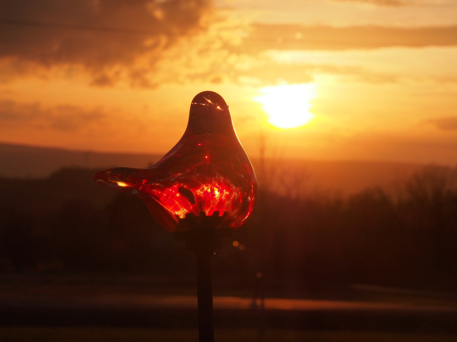 LED lawn bird in the foreground before a golden setting sun