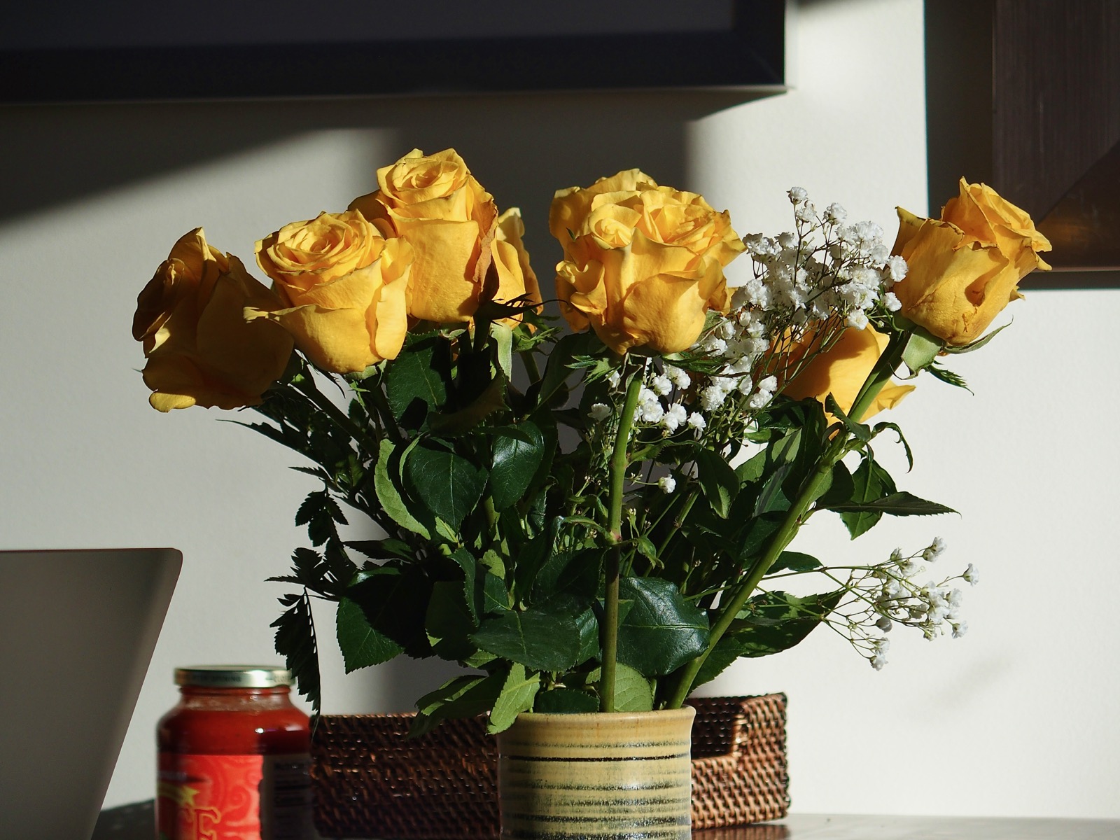 Yellow roses in a ceramic vase in low early morning light