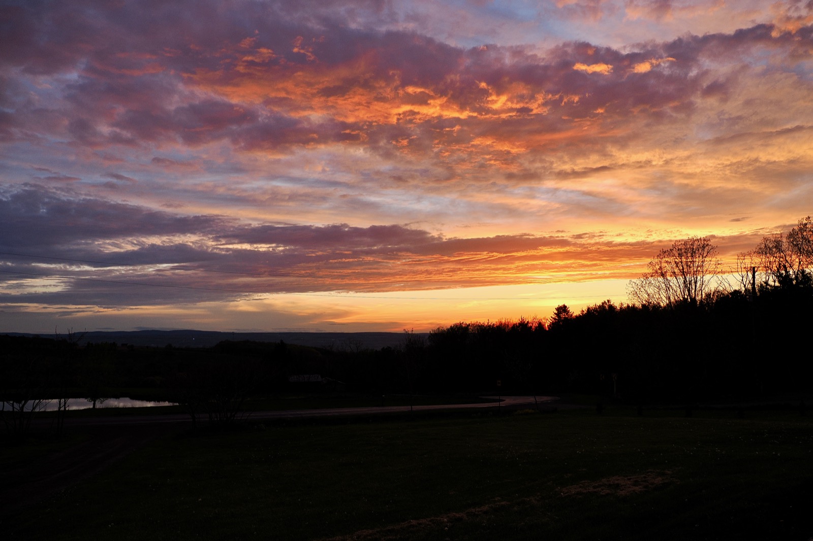 Clouds illuminated in orange and yelloy from below by the setting sun.