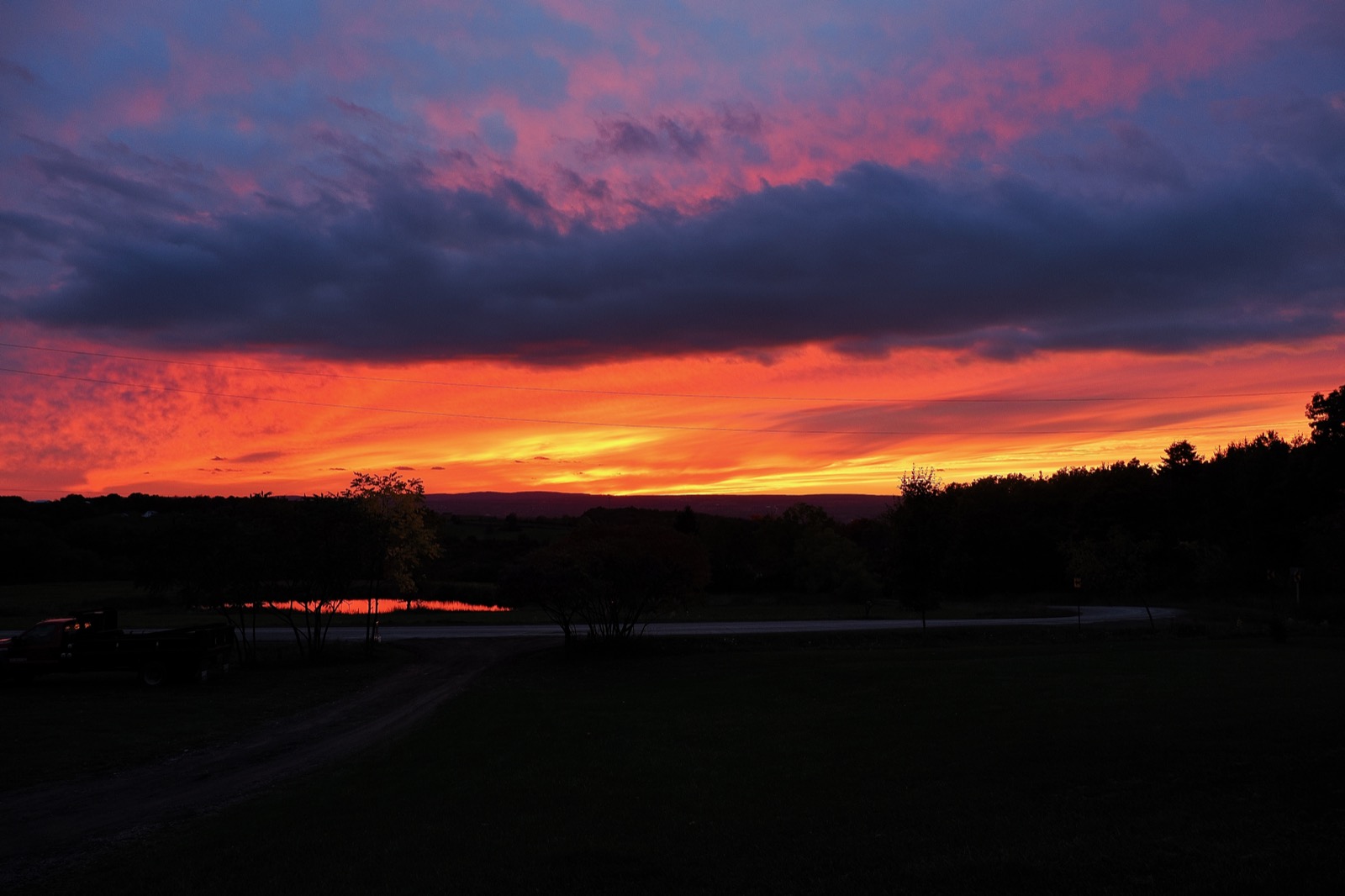 Clouds illuminated from below in red and gold light from the setting sun
