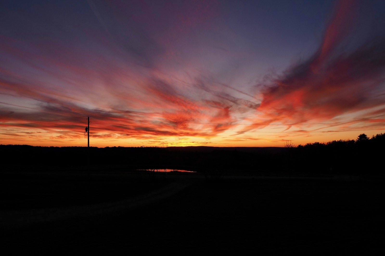 Clouds illuminated in red with yellow and gold on the horizon 